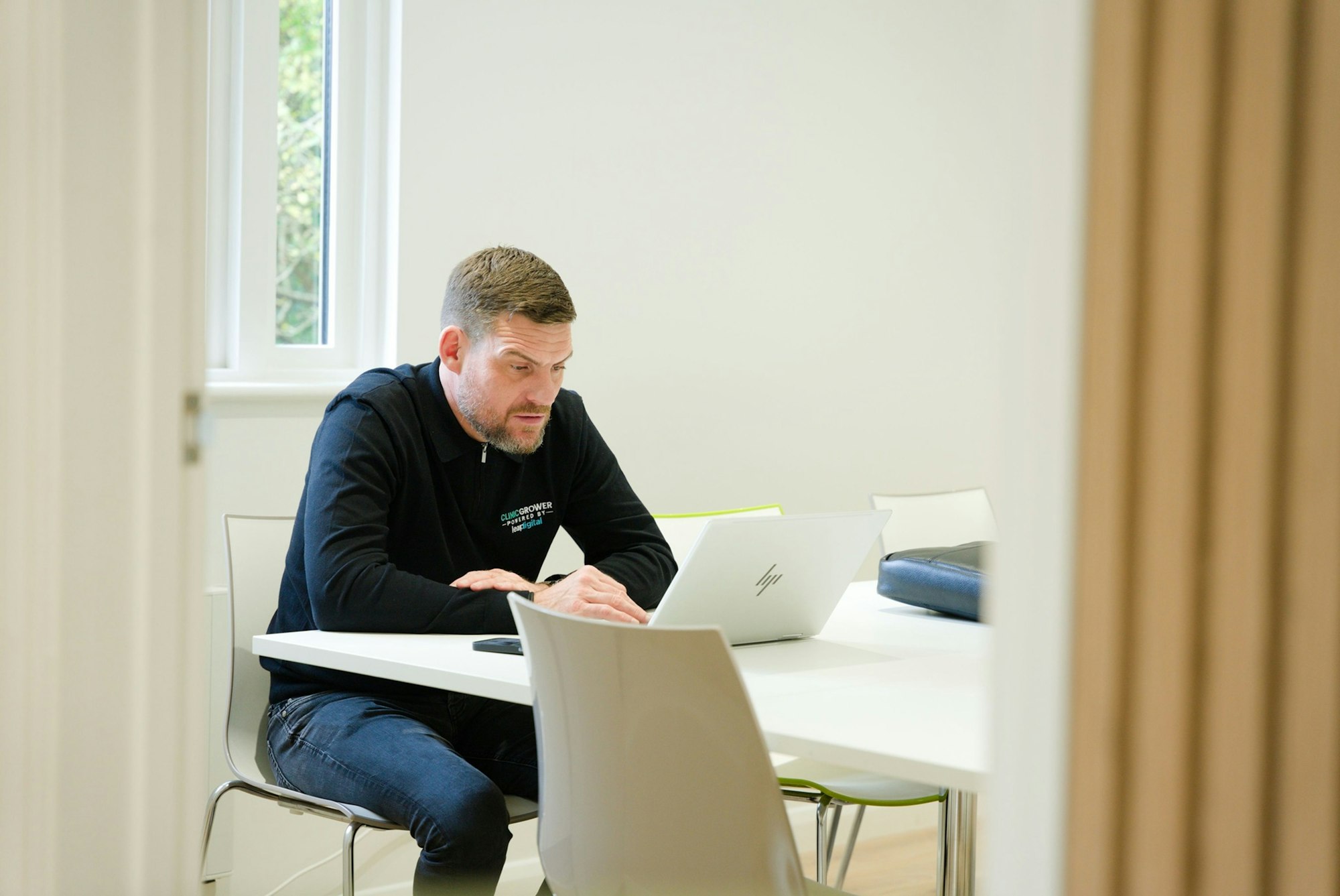 Professional reviewing a training certificate on a laptop at a desk
