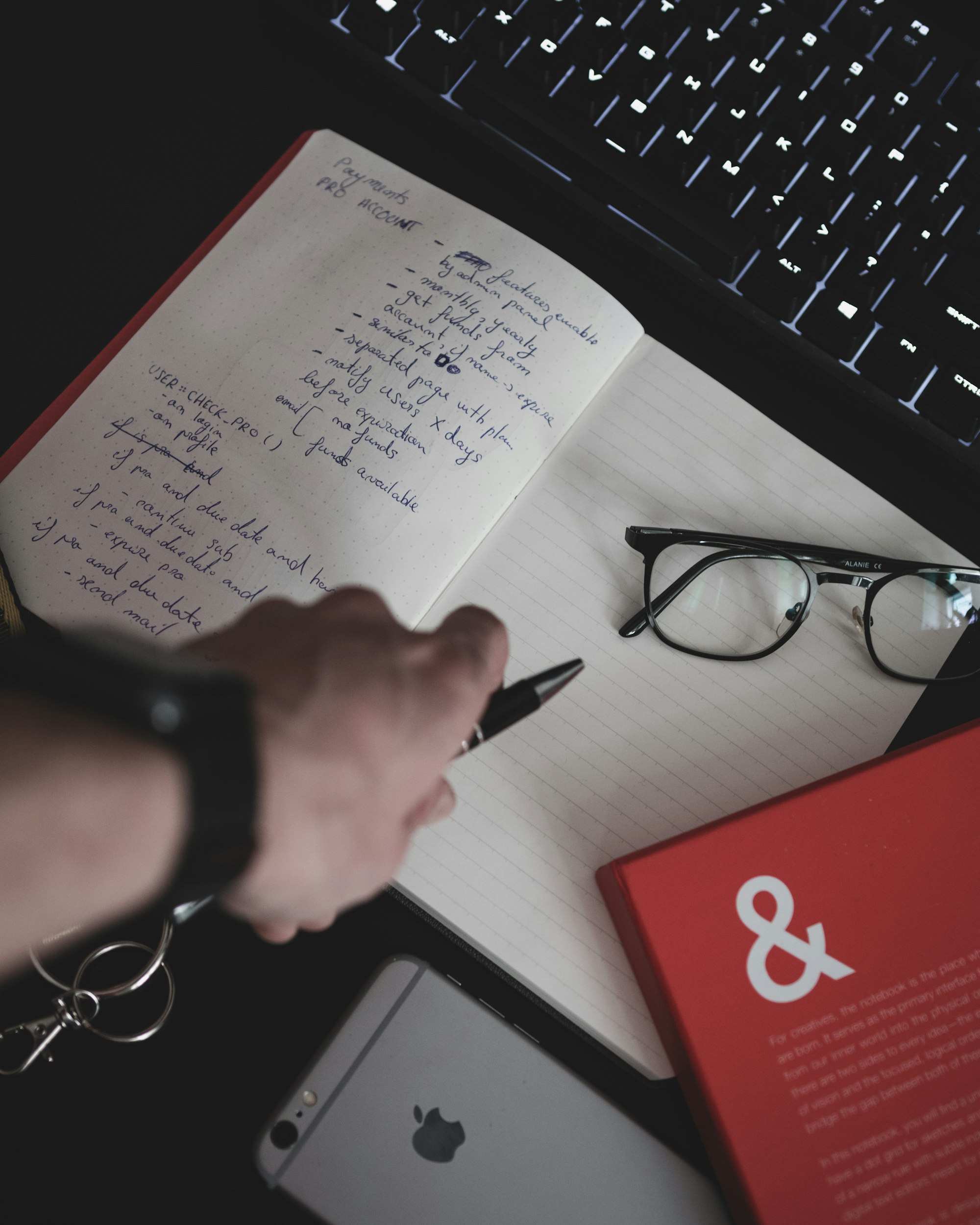 Professional making a shortlist in a notebook next to a laptop