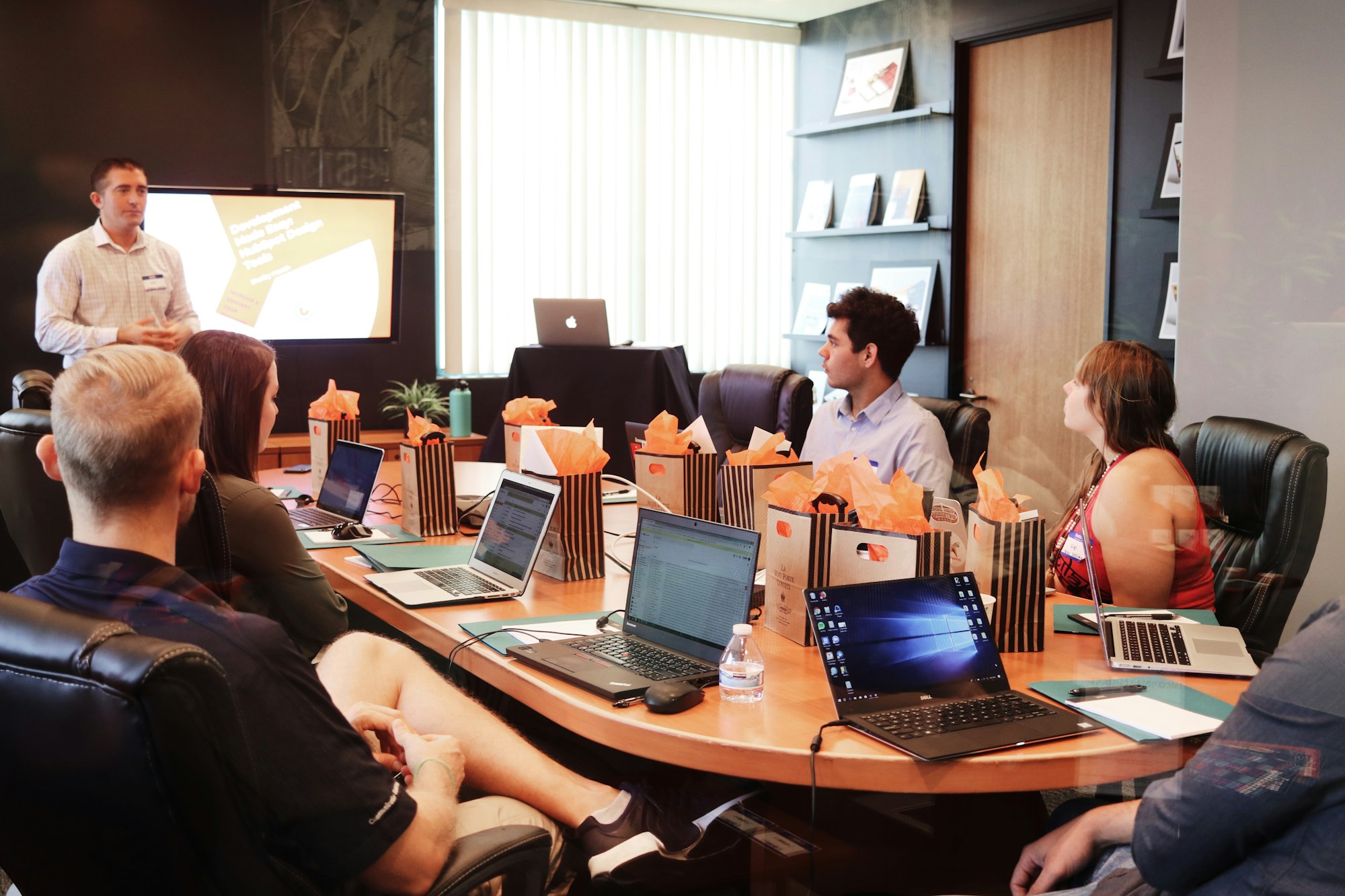 Small group customer service training session with notebooks and laptops