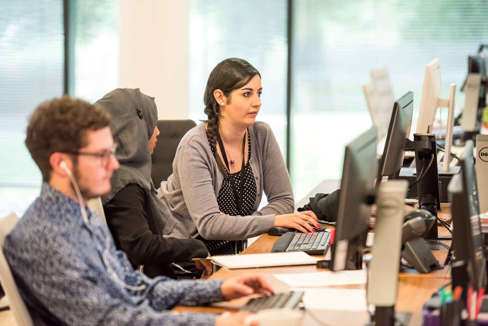 Team in a training session reviewing customer service performance dashboards on a screen
