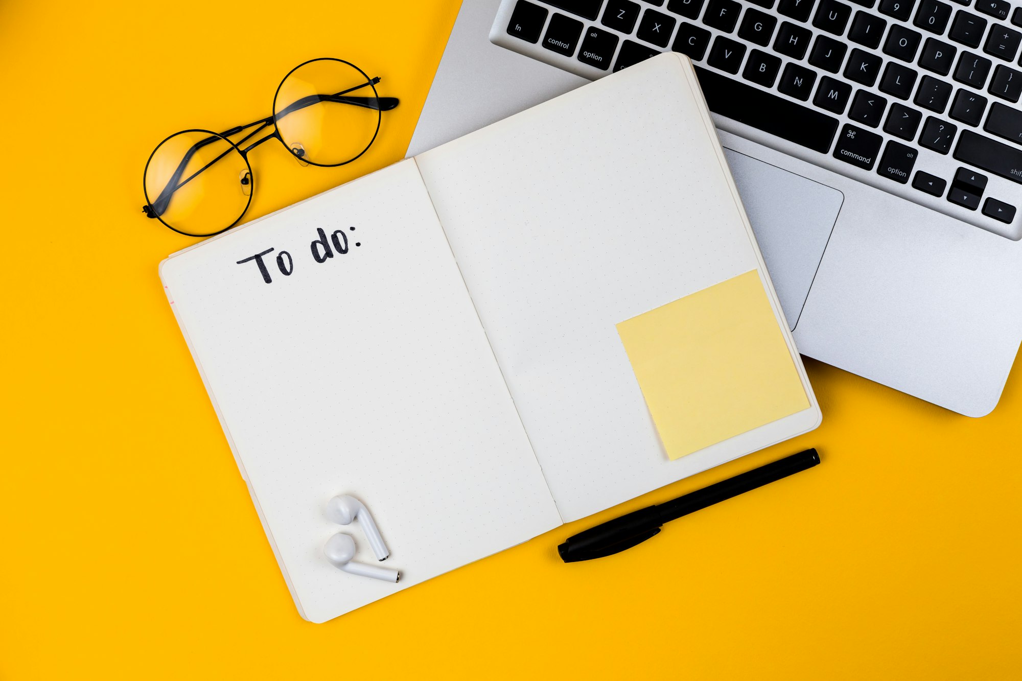 Certificate and notebook on a desk with a pen and laptop