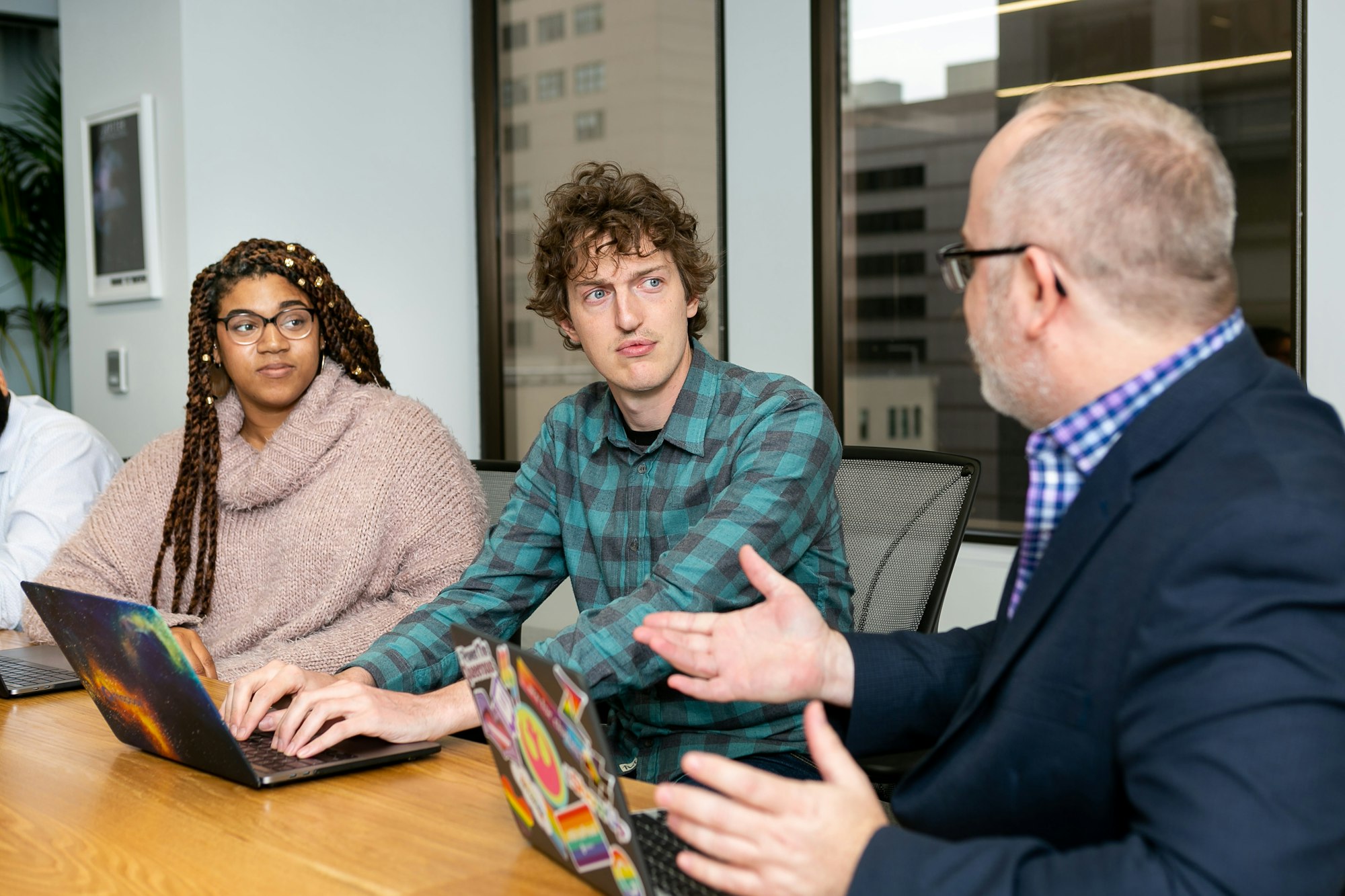 Customer service supervisor discussing an escalation with team members in a small meeting