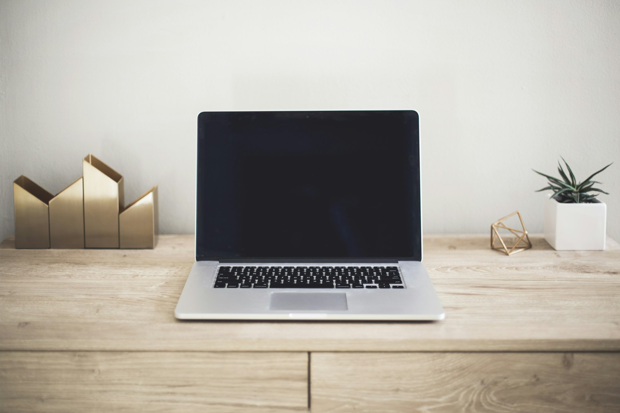 Professional studying an online course on a laptop with notes beside the keyboard