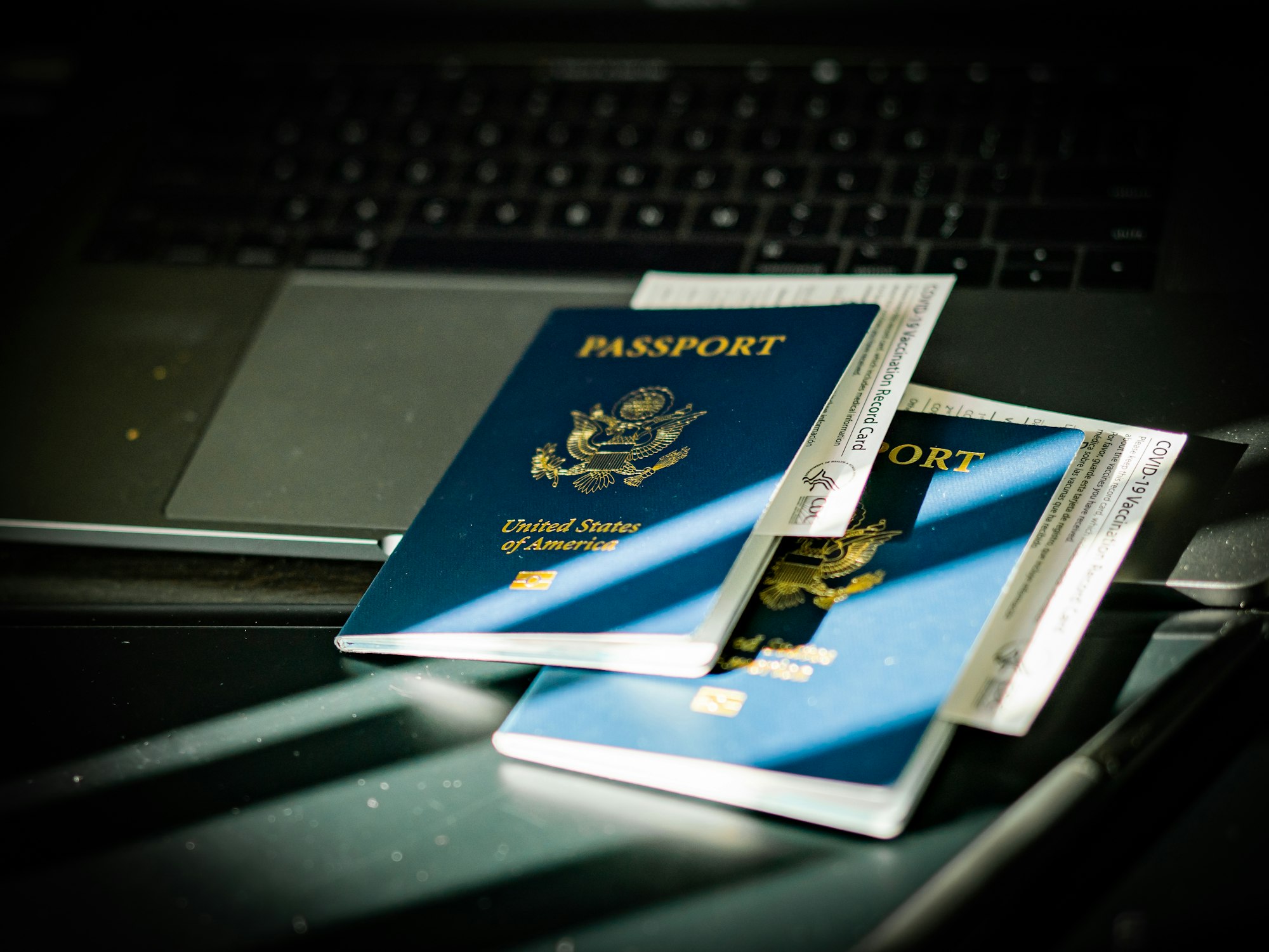 Passport and laptop on a desk, suggesting international professional mobility
