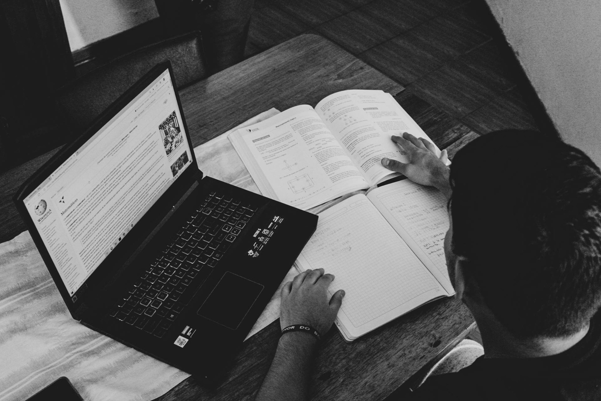 A professional taking an online course on a laptop with a notebook