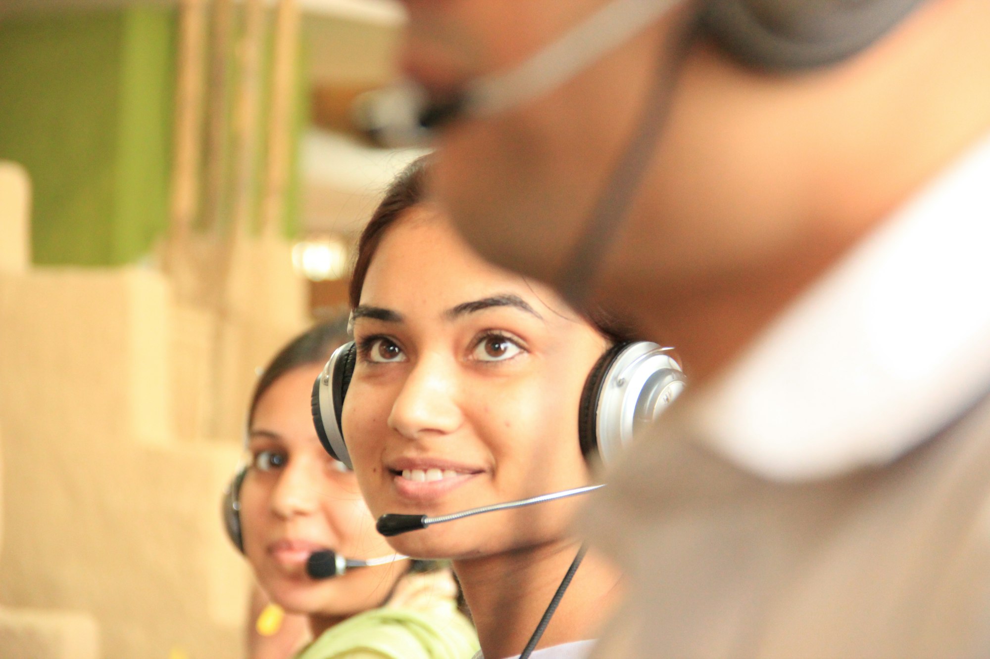 Customer service professional using a laptop and headset at a modern desk