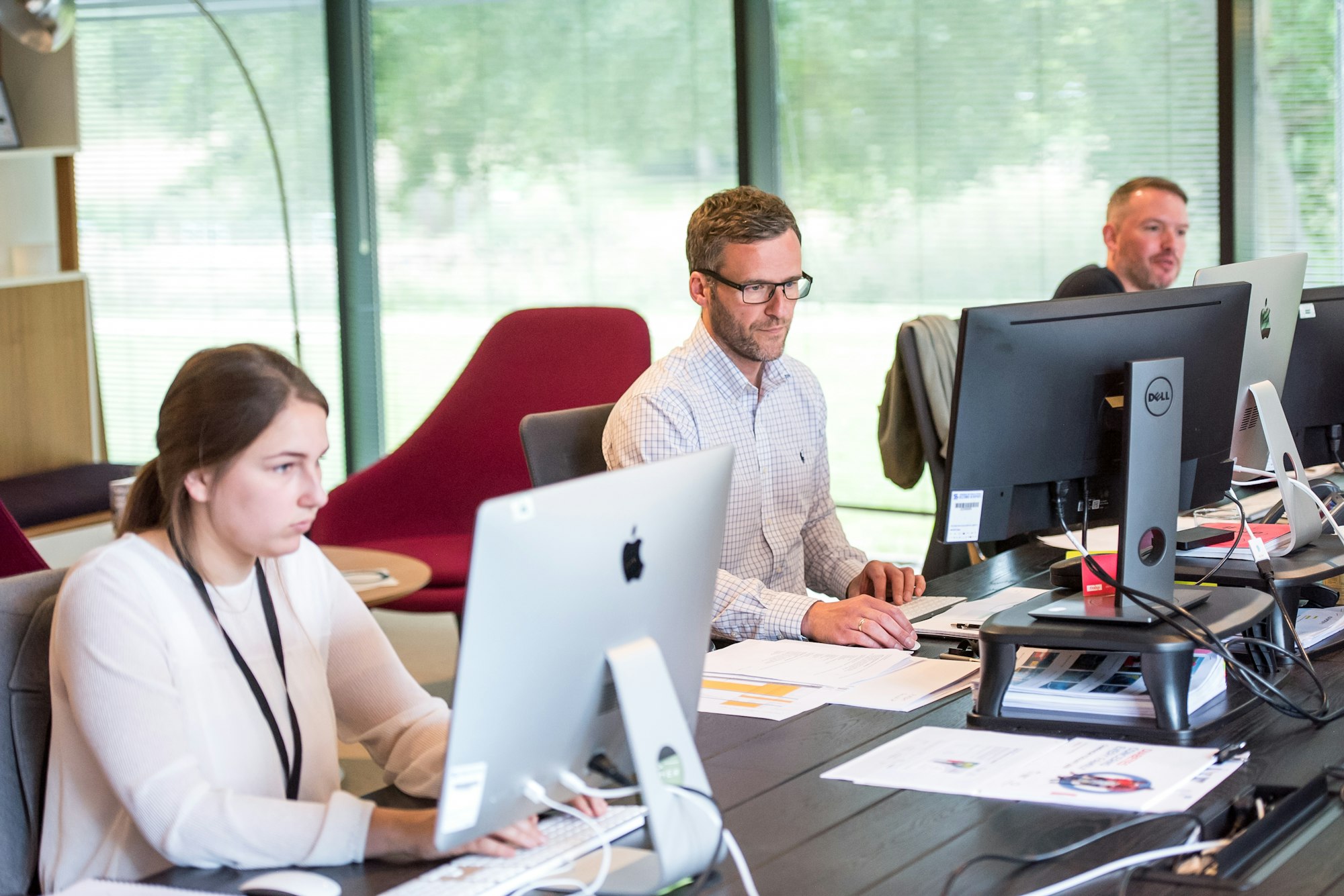 Customer service manager reviewing team performance on a laptop in an office setting